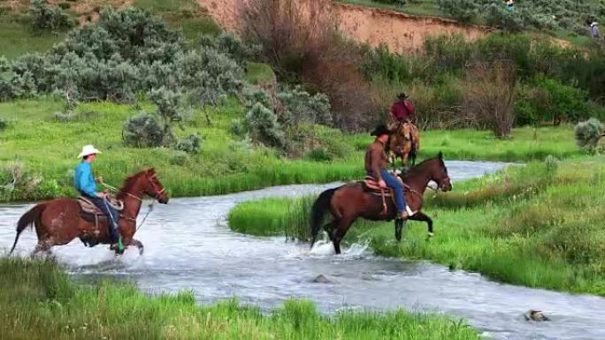 牛仔和女牛仔骑马穿过河