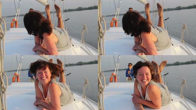 快乐的女人躺在帆船甲板上，与船员调情