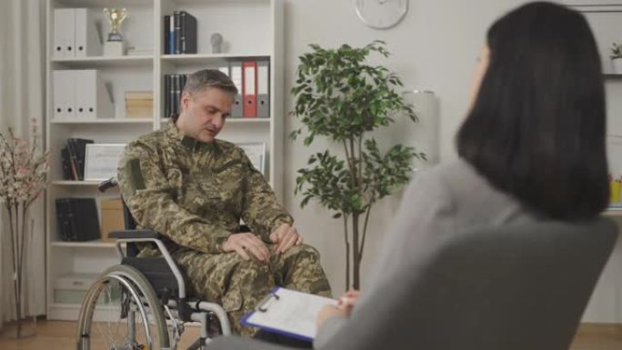 退伍老兵轮椅使用者拜访心理医生，进行心理健康治疗