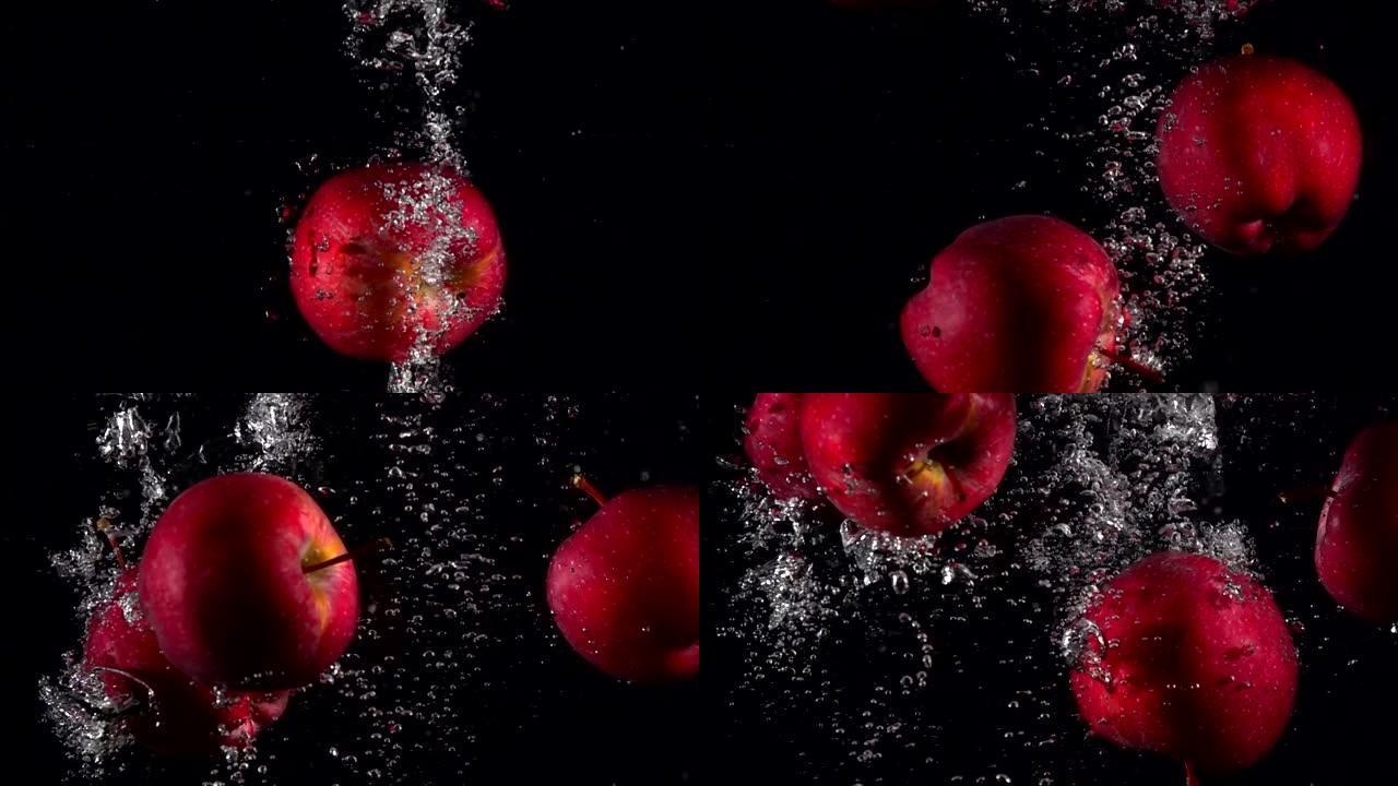 慢动作红苹果在黑色背景下落水。美丽的新鲜水果在水族馆里飞溅。有机水果，健康食品，饮食，概念。以4k 