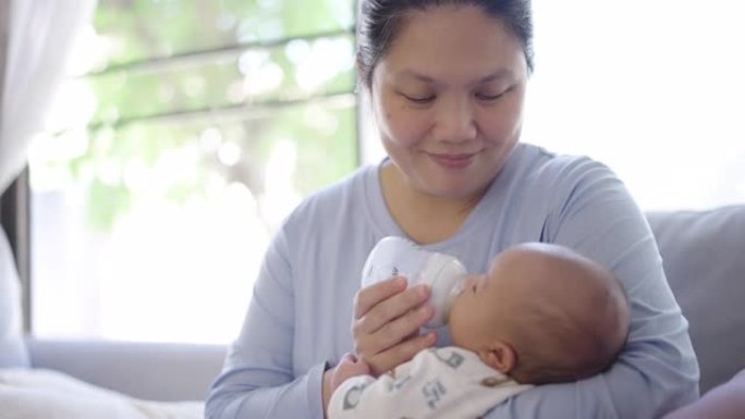 母亲用婴儿奶瓶喂养婴儿