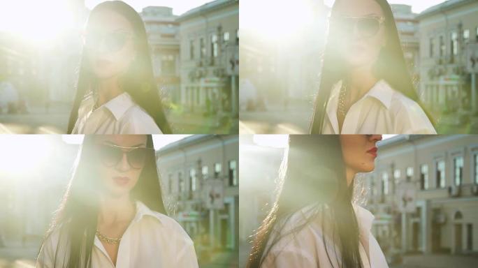 穿着白衬衫的时尚黑发女人在早晨的阳光中摆姿势拍照