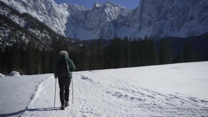 男子在雪地里徒步旅行，远离山线附近的观众