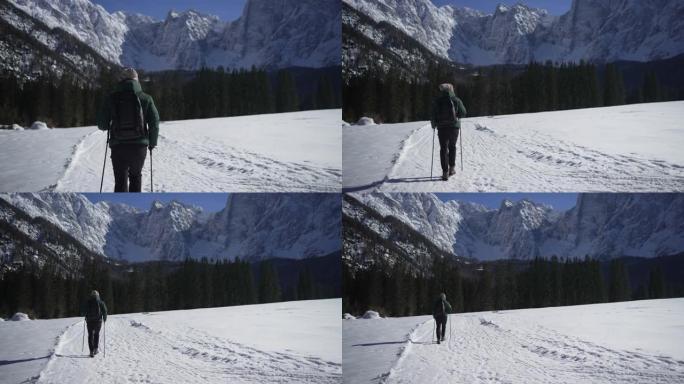 男子在雪地里徒步旅行，远离山线附近的观众