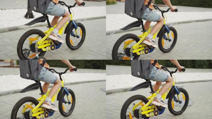 匿名儿童骑着带训练轮的自行车