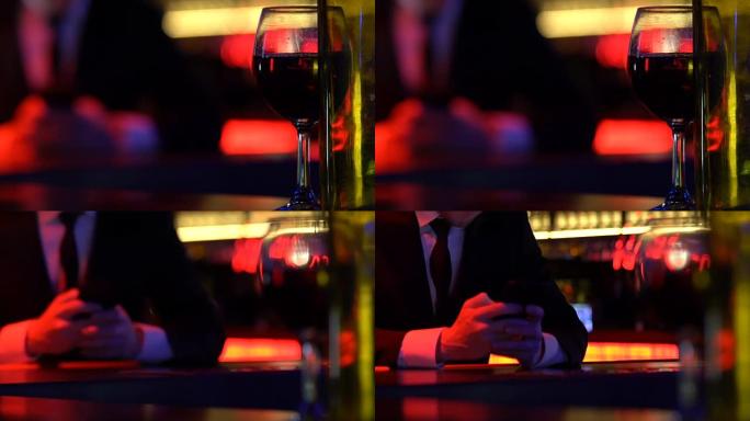 年轻人在空酒瓶附近发短信给智能手机，酒精酒吧放松
