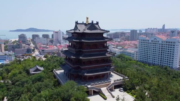 中国威海市环翠楼塔的空中电影完整轨道，蓝天，背景令人叹为观止。