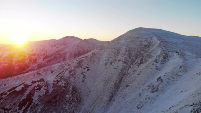 日落时雪山脊的空中无人机视图