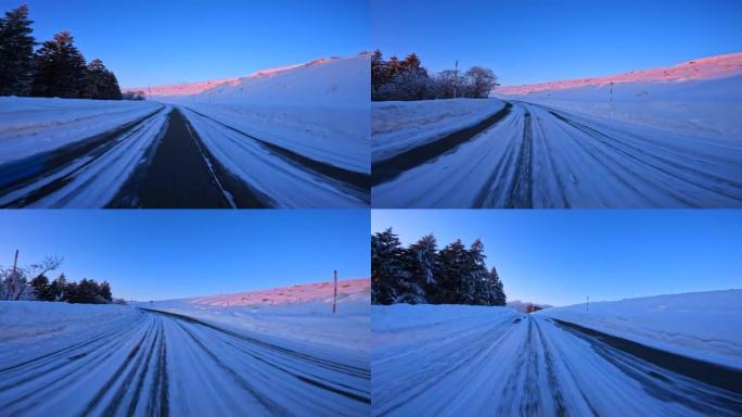 黄昏时在雪山路上行驶。