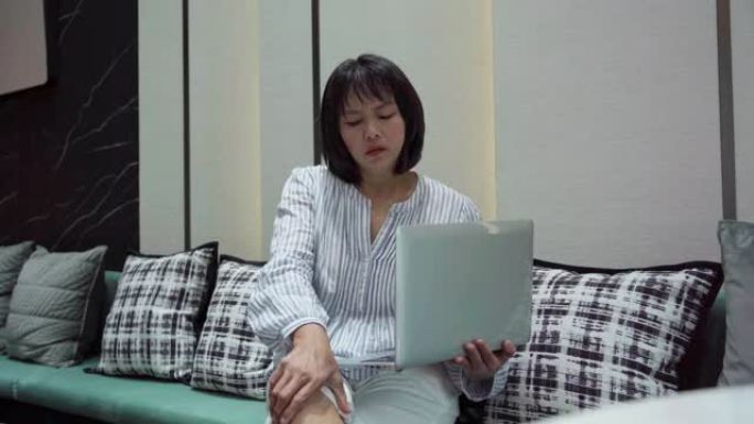 亚洲成熟女性使用笔记本电脑痛苦感到疼痛突然疼痛膝盖和关节肌肉劳损