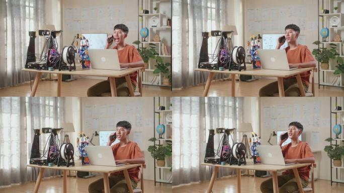 亚洲男孩在家里的笔记本电脑上工作时在智能手机上聊天