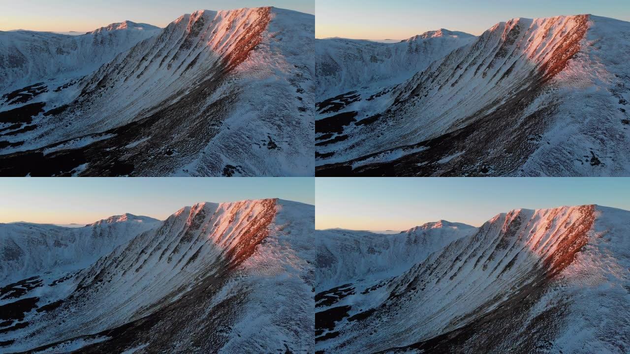 日落时雪山脊的空中无人机视图