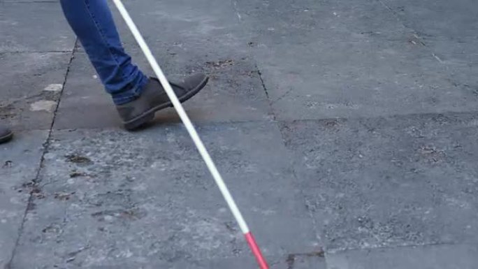 盲人用白拐杖走在街上。独立，残疾