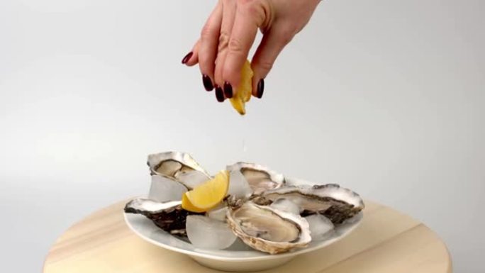 大厨在木托盘上烹制的牡蛎特写镜头，以大海为背景的柠檬为背景。海鲜美食。牡蛎农场种植的美味牡蛎。