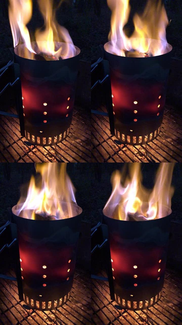 用燃烧的木炭在烟囱启动器中进行烧烤准备，并随着热而泛红