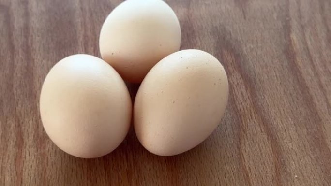 三个鸡蛋在木桌上旋转