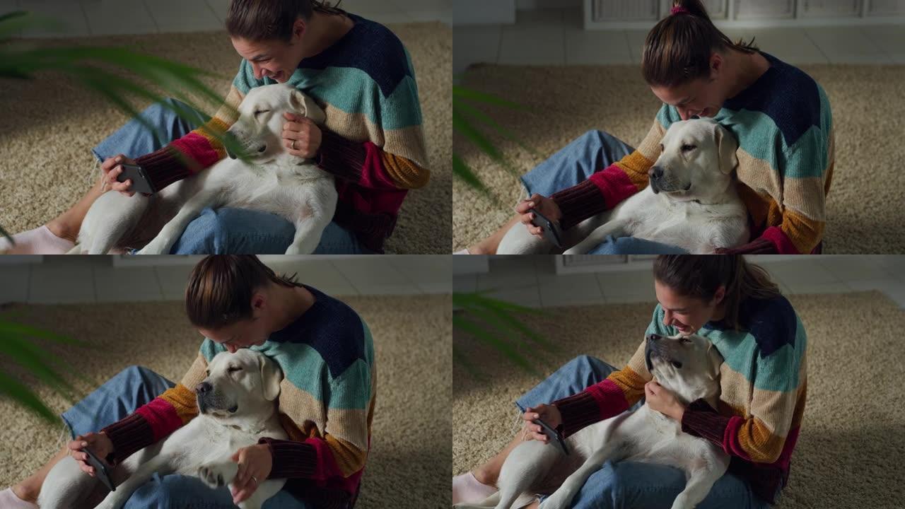 一位年轻女子的肖像，她的大腿上放着可爱的拉布拉多犬狗，与家人和朋友一起使用智能手机进行视频拍摄。听话