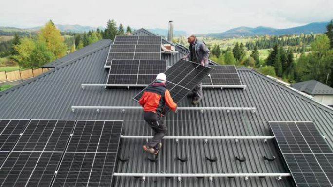 技术人员在屋顶安装太阳能电池板系统时携带光伏太阳能组件