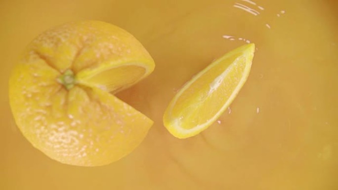 橙子在果汁上分裂成haslice lves。慢动作镜头