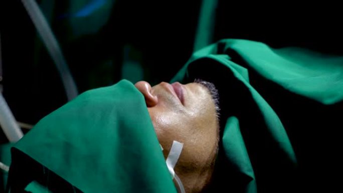 4K，特写病人躺在手术床上，护士用绿色的布遮住眼睛，覆盖她的身体，同时准备手术使用麻醉，防止病人在手