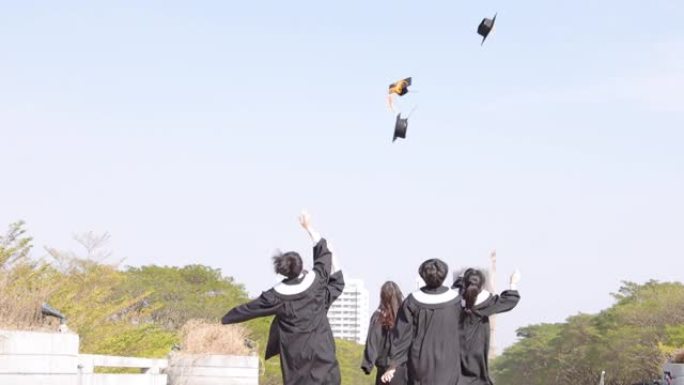 快乐的学生在空中奔跑和扔毕业帽