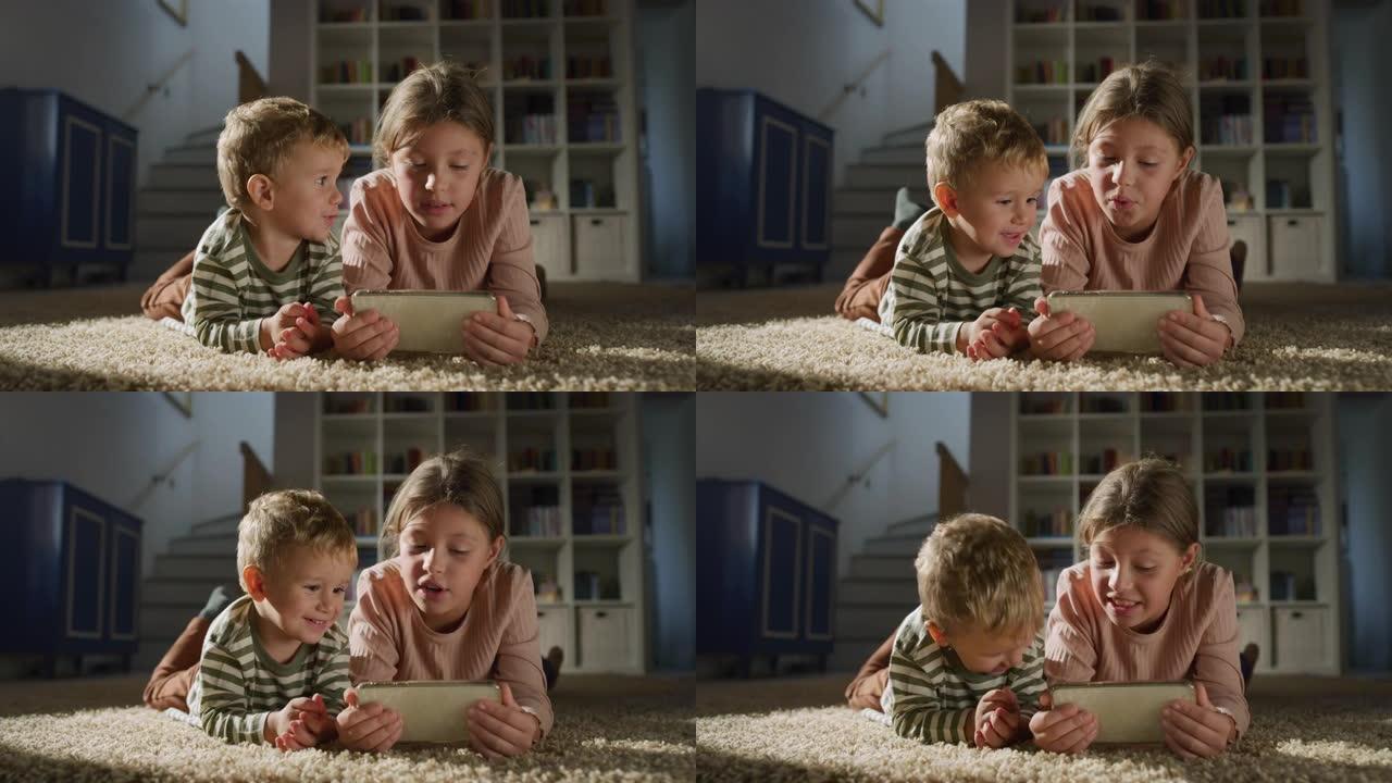 一个小男孩蹒跚学步和他的妹妹在智能手机上观看视频的肖像。快乐的兄弟姐妹使用电话，与儿童游戏一起唱歌。