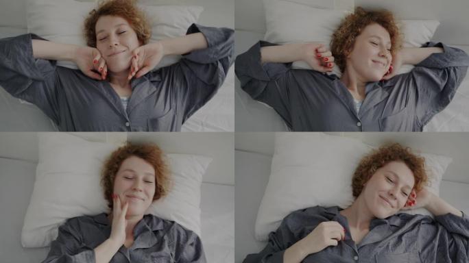 顶视图肖像迷人的红发女人雀斑醒来在床上伸展和微笑