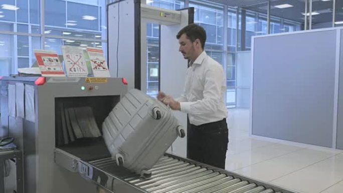 商人在机场通过x射线扫描仪扫描后等待行李