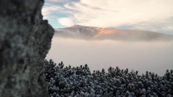 雪，云和雾在下面滚动的山脉的风景