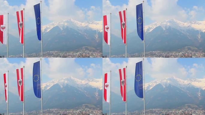 旗帜与欧盟，奥地利，蒂罗尔的标志在空中飘扬，山脉