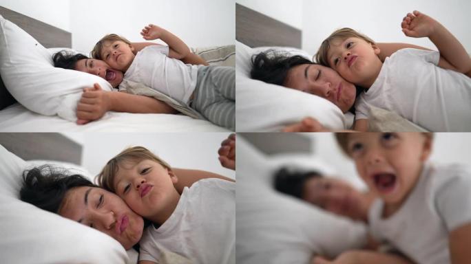 母亲和孩子躺在床上的可爱生活时刻，表现出爱和感情。机缘概念