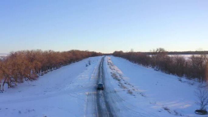 黑车在雪中行驶在城外公路，后视