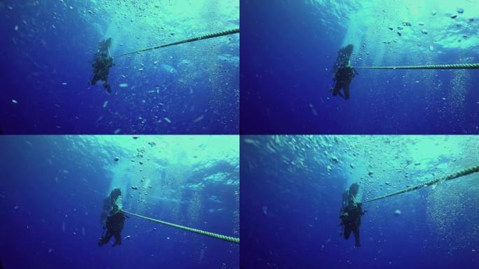 勇敢的潜水员通过电缆下降到海底。