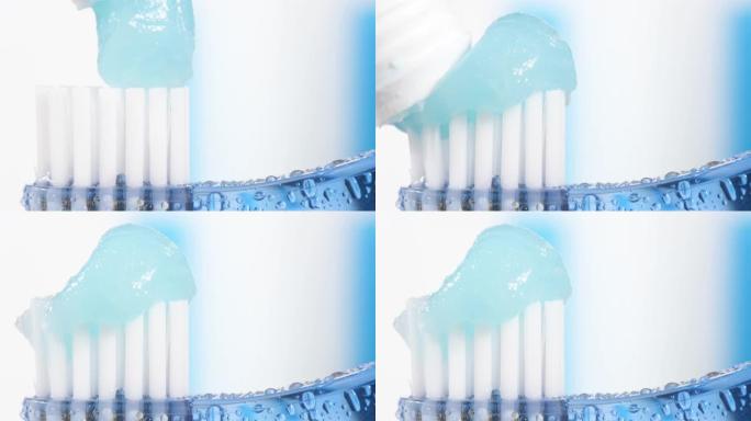 牙刷和牙膏。蓝白色背景上挤压牙膏的水滴蓝色牙刷的宏观视图。慢动作视图