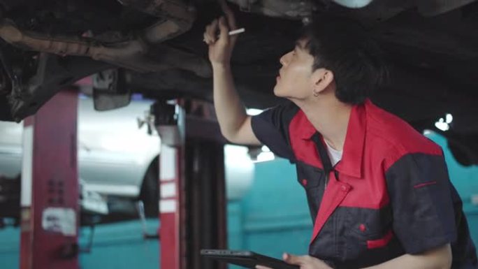 汽车服务、维修、保养理念。机械师在服务站检查汽车。车辆服务维护亚洲男子在车库检查汽车。