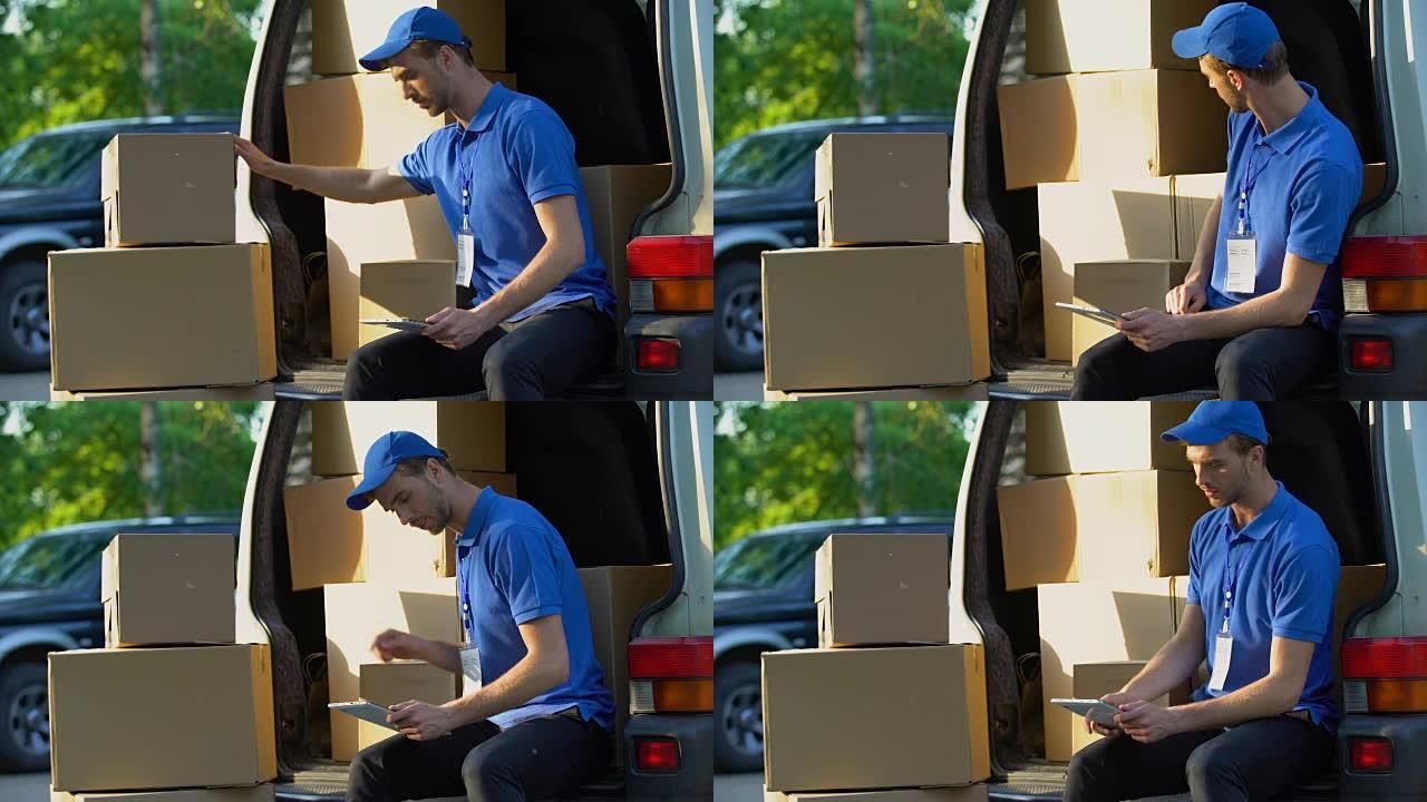 送货员在面包车中检查包裹金额，平板电脑上的盘点报告