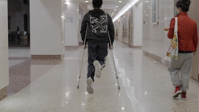 医院急诊 脚踝扭伤拄拐杖的男孩