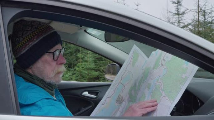 退休男子坐在车里看地图