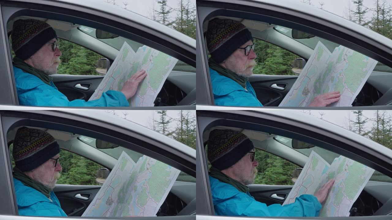 退休男子坐在车里看地图