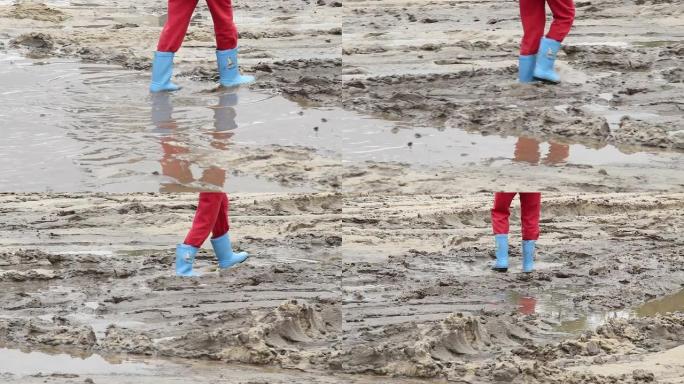 儿童脚在水坑泥土上行走，蓝色靴子，儿童不安全