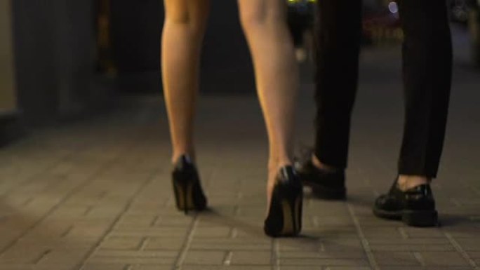 男女腿走在街上经过陈列柜，去夜总会，约会
