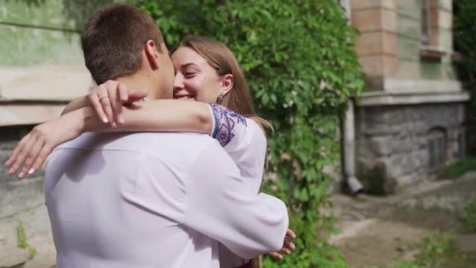 多元化的千禧一代夫妇在老房子背景下会面，互相拥抱。