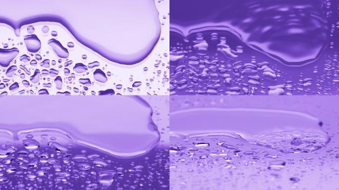 两个水滴滴在大水滴上，溅到紫色背景上
