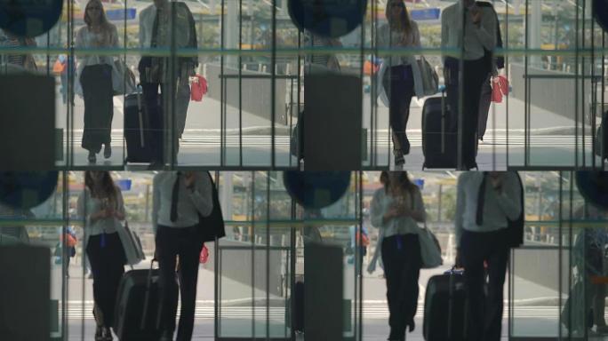 穿着长裙的男人和女人通过自动开门进入机场大厅