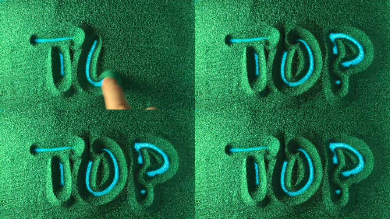 在绿色的沙滩上手工绘制单词Top。
