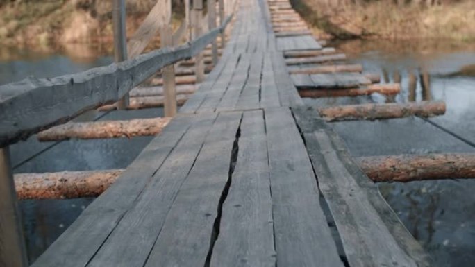 秋天森林中河上的旧木吊桥，傍晚柔和的阳光，秋天的季节