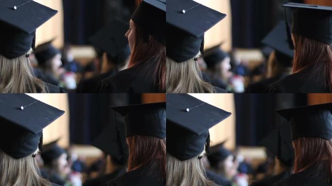 戴着学术帽的女学生在毕业时听讲座