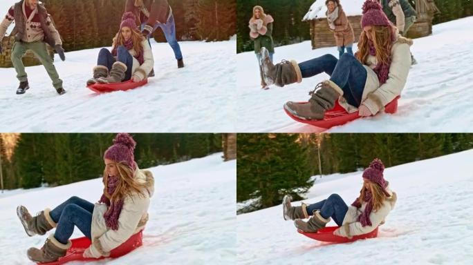 SLO MO Man推着他笑着的女性朋友在雪地雪橇上下山