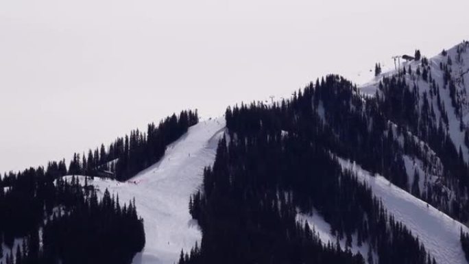 在阿斯彭高地滑雪场跑步的滑雪者的超级长焦视频。科罗拉多州阿斯彭。