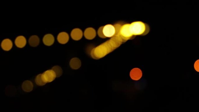 夜间黑暗模糊背景中的Bokeh，城市灯光的Bokeh，散焦的夜间交通信号灯，玻璃状圆形